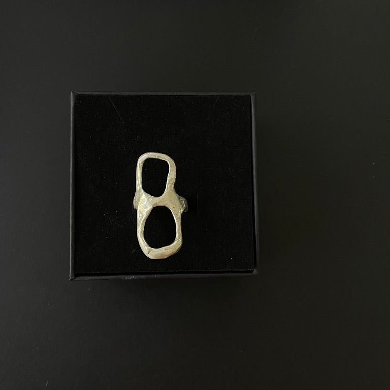 Silver ring on a black display box against a dark background